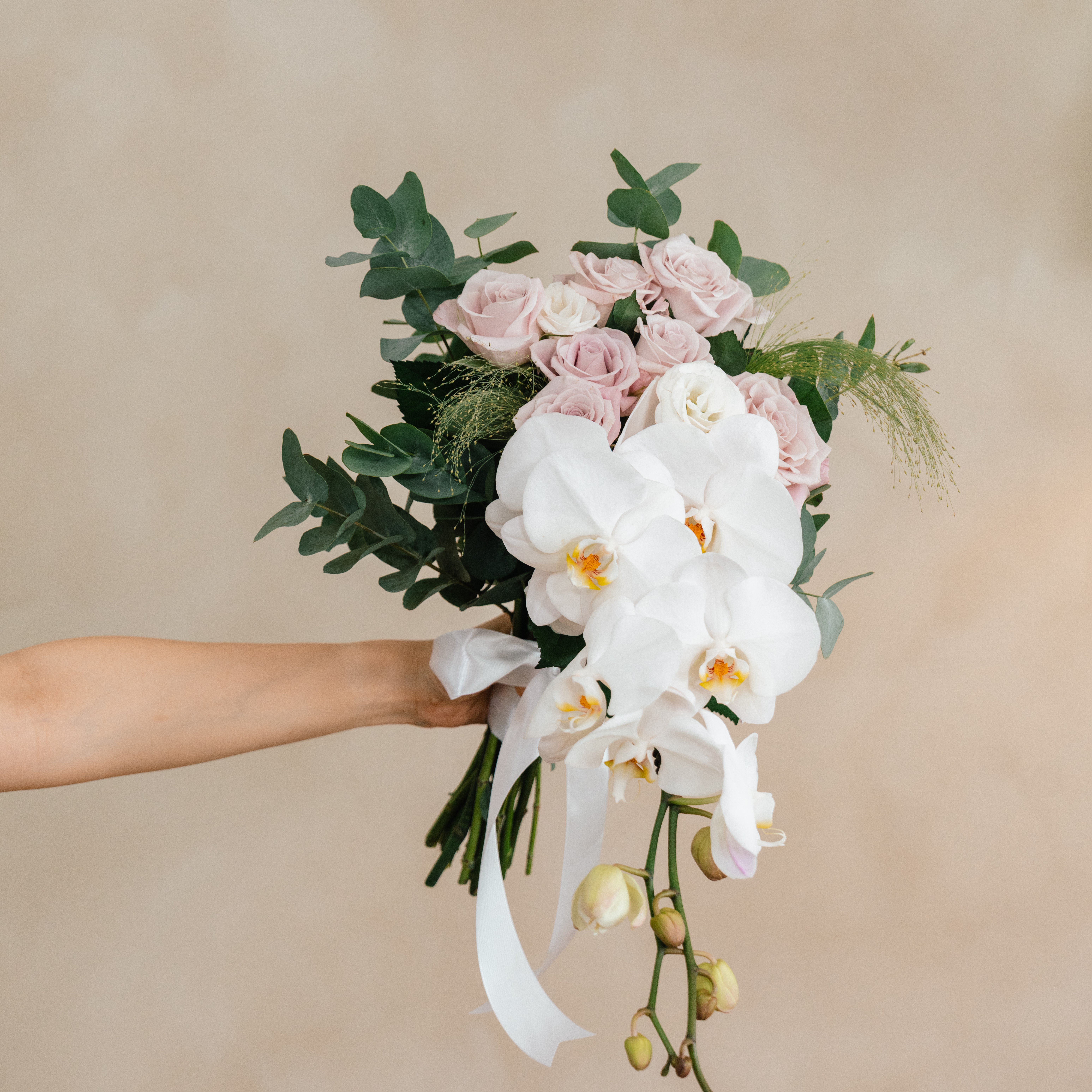 a person holding a Ivory Kiss Bridal Bouquet